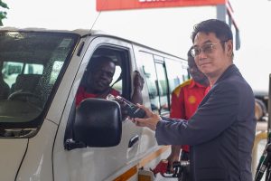 Managing Director of Vivo Energy Ghana, Christian Li handing over a reusable bottle to a customer at Ai